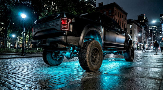 Lifted truck glowing with blue underbody lights at night