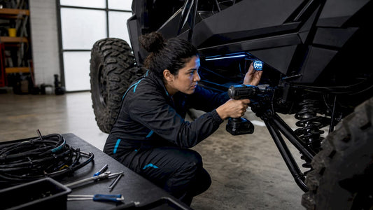 Mechanic installing rock lights on SXS vehicle