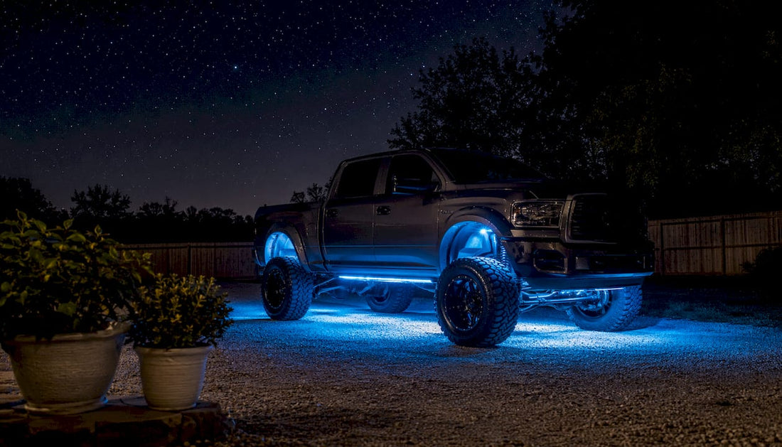 Lifted truck with blue underbody glow lights on driveway