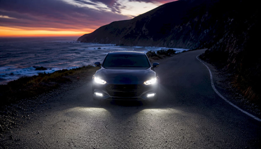 Modern car with bright LED headlights on highway at dusk