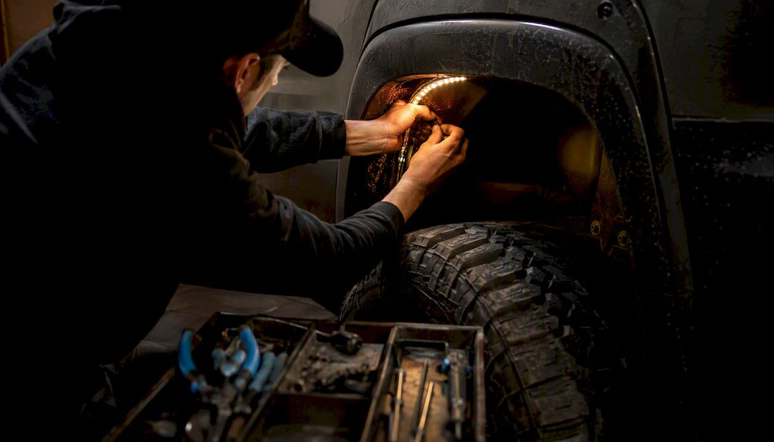 Hands installing amber LED wheel lights on truck