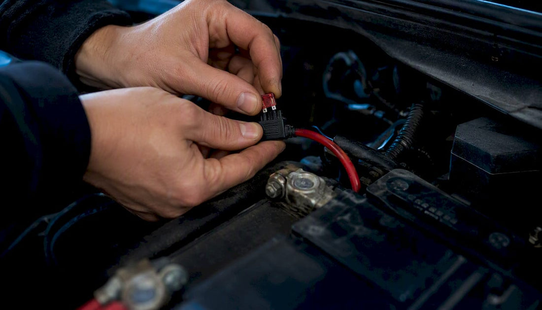 Hands installing automotive blade fuse close-up