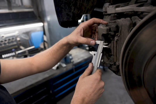 Hands measuring caliper clearance near wheel