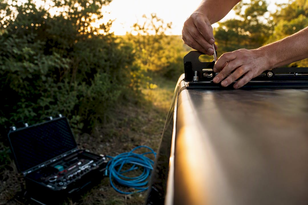 Close-up hands mounting light bar on lifted truck roof