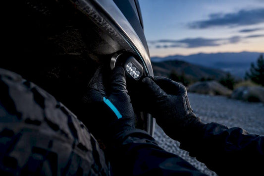 Hands attaching a magnet mounted rock light